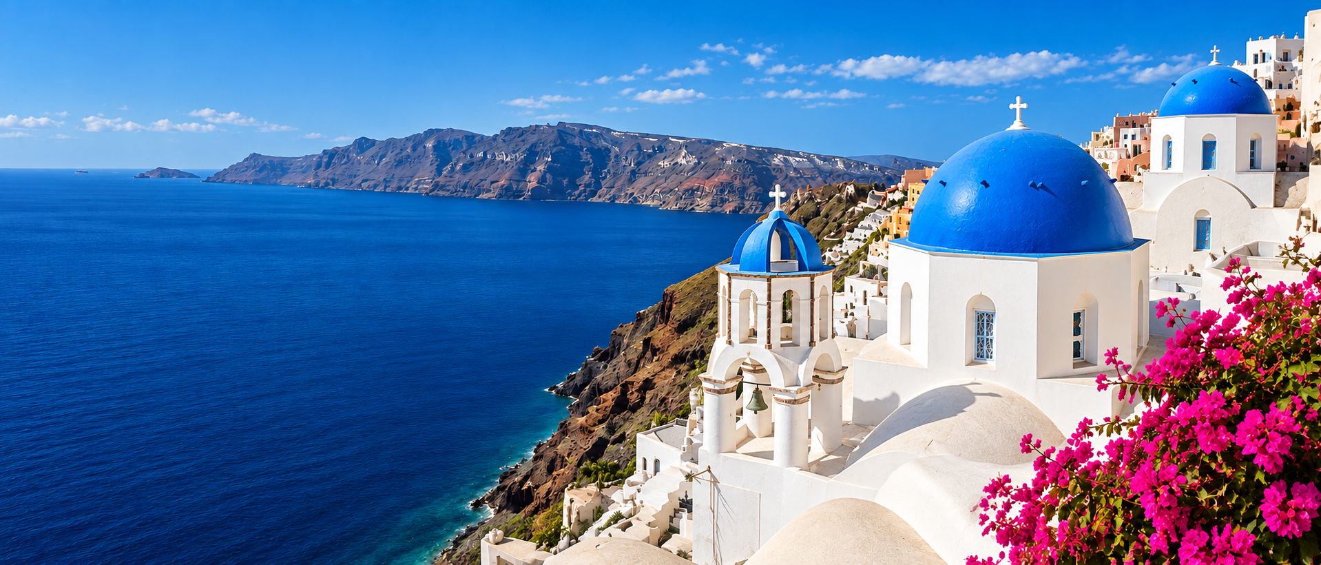 Blue-domed churches overlook the Aegean Sea at Oia, Santorini, Greece