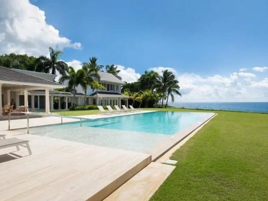A private infinity-edge pool at an oceanfront villa, framed by palm trees